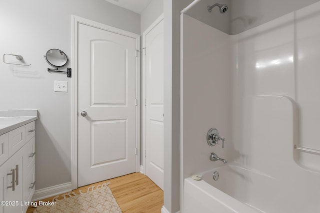 bathroom featuring shower / washtub combination, hardwood / wood-style floors, and vanity