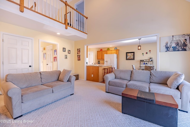 carpeted living room featuring a high ceiling