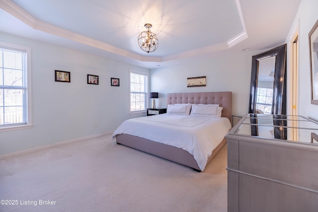 carpeted bedroom with a tray ceiling and a notable chandelier