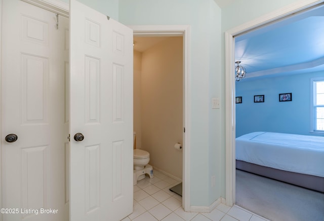 bathroom featuring toilet, tile patterned flooring, and a notable chandelier