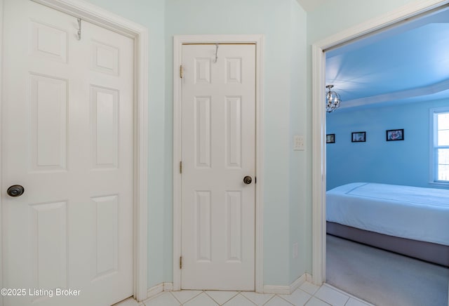 hall with an inviting chandelier and light tile patterned floors