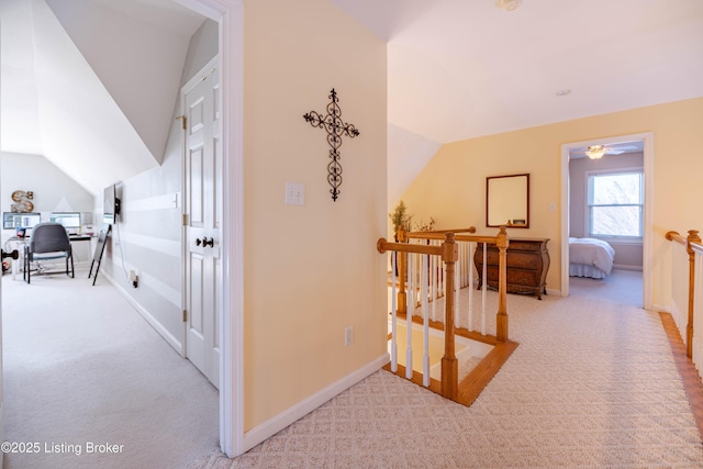 corridor with lofted ceiling and light colored carpet