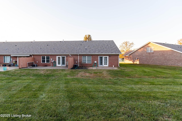 back of property featuring a patio, a lawn, and french doors