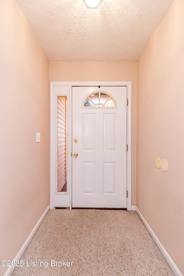 doorway to outside featuring a textured ceiling