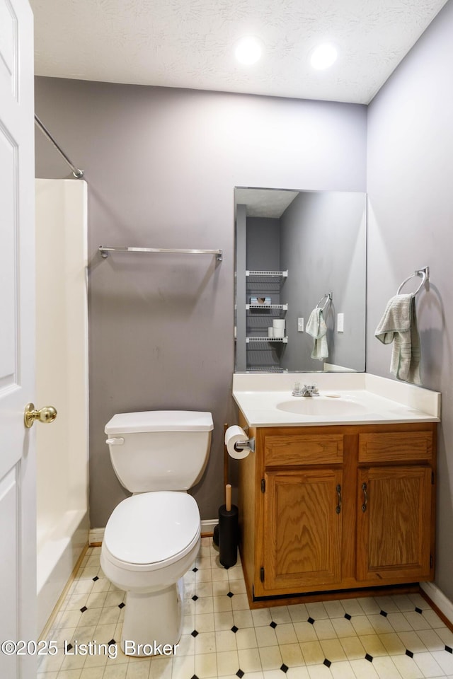 bathroom with walk in shower, vanity, and toilet