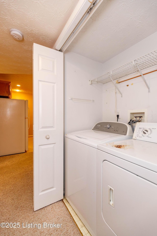 laundry area with washer and dryer and a textured ceiling