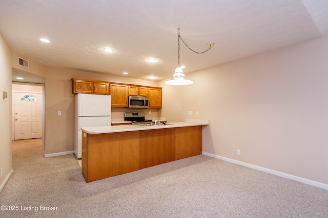 kitchen with stainless steel appliances, hanging light fixtures, light carpet, and kitchen peninsula