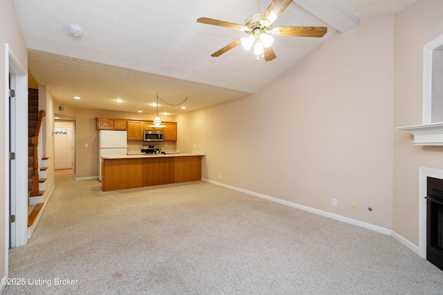 kitchen featuring light colored carpet, hanging light fixtures, appliances with stainless steel finishes, kitchen peninsula, and ceiling fan