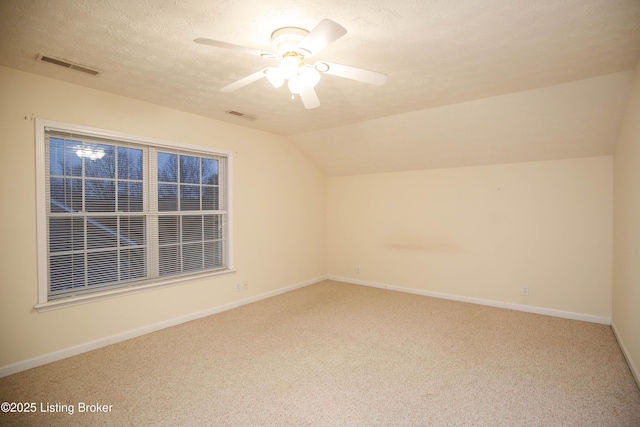 additional living space with lofted ceiling, ceiling fan, a textured ceiling, and carpet