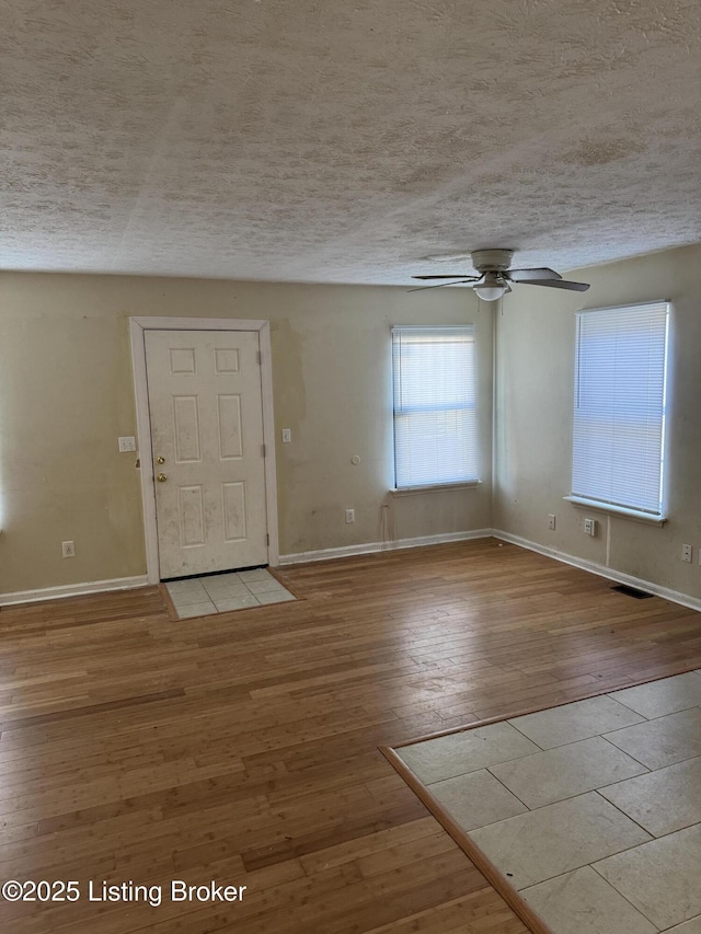 entrance foyer featuring ceiling fan, light hardwood / wood-style floors, and a textured ceiling