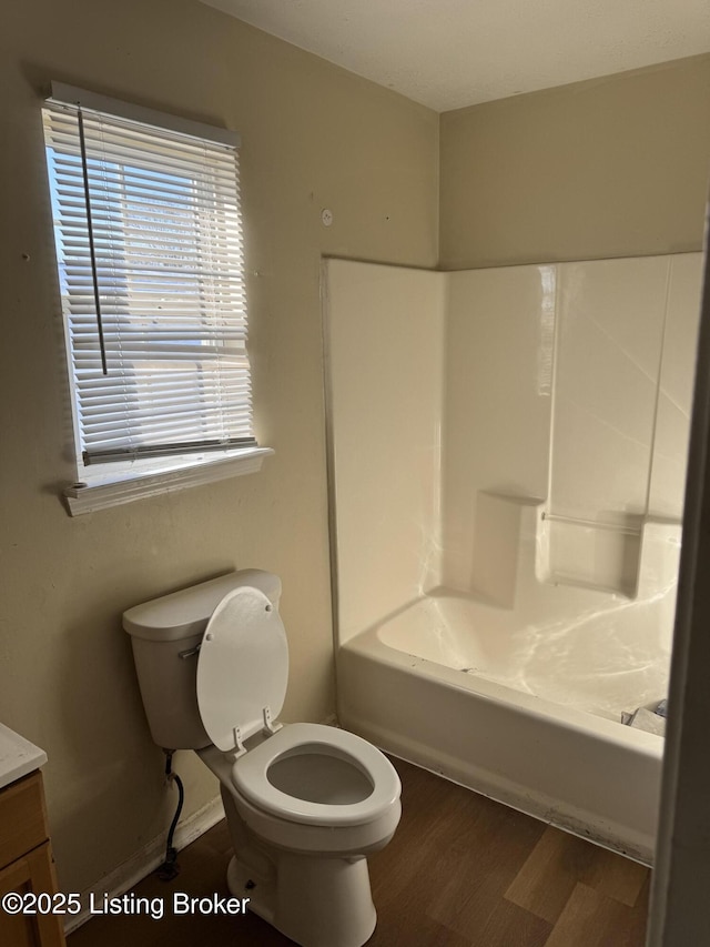 full bathroom featuring hardwood / wood-style flooring, vanity, bathtub / shower combination, and toilet