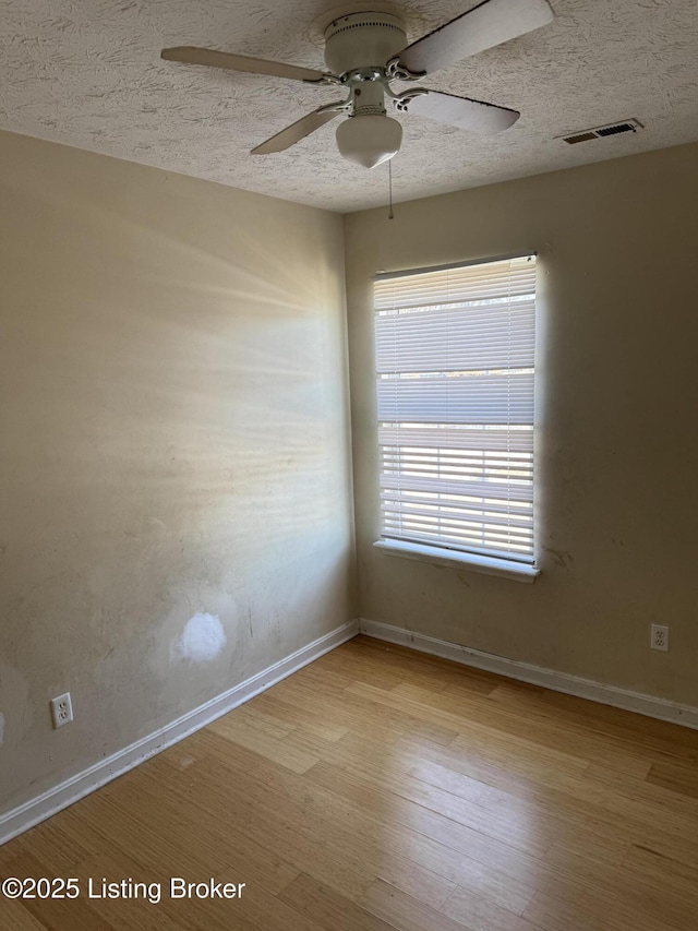 spare room with ceiling fan, a textured ceiling, and light hardwood / wood-style flooring