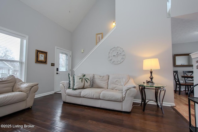 living room featuring dark wood-type flooring and high vaulted ceiling