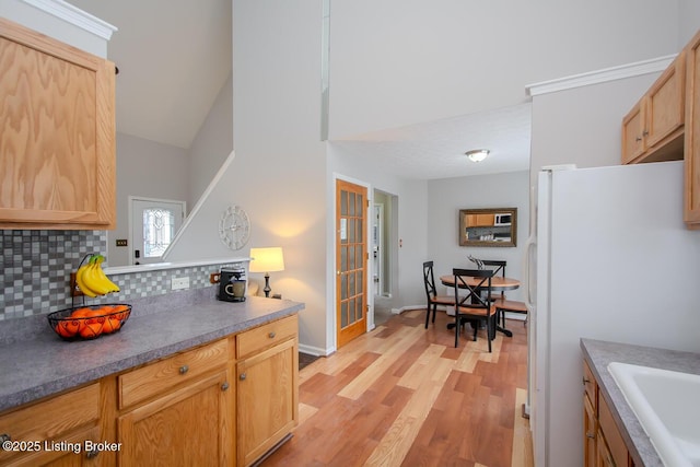 kitchen featuring sink, white fridge, tasteful backsplash, light brown cabinetry, and light wood-type flooring