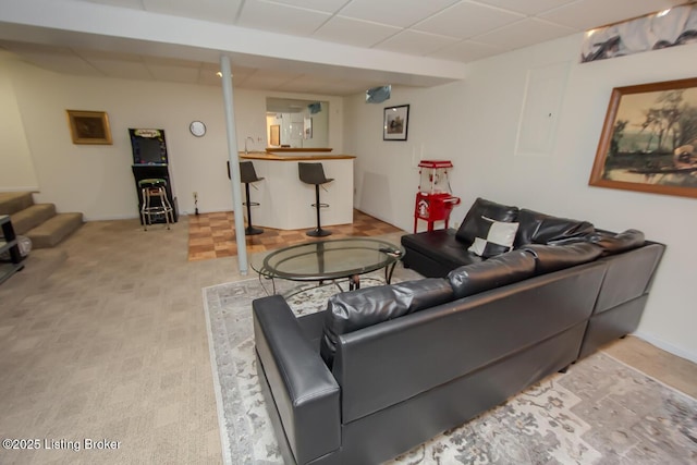 living room with a paneled ceiling and bar area