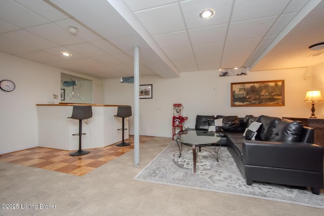 carpeted living room featuring a paneled ceiling