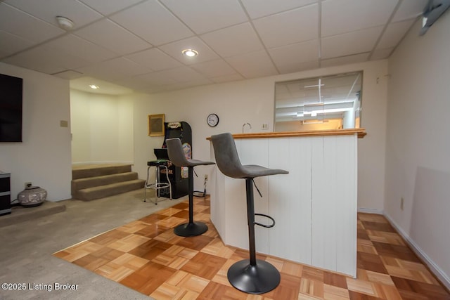 workout area featuring light parquet flooring and a drop ceiling