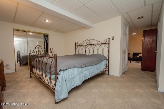 carpeted bedroom featuring a drop ceiling