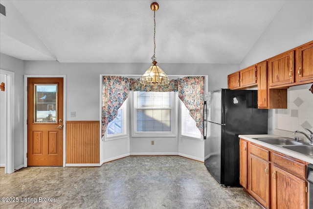 kitchen with vaulted ceiling, plenty of natural light, sink, and decorative light fixtures