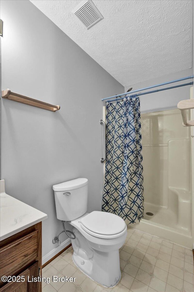 bathroom with vanity, curtained shower, a textured ceiling, and toilet