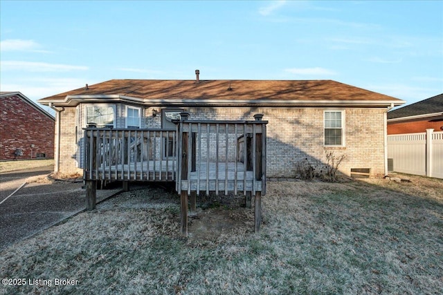 rear view of house with a yard and a deck