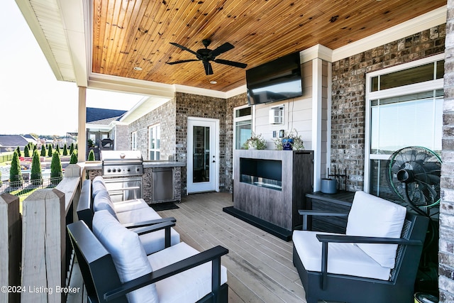 view of patio / terrace with ceiling fan, a wooden deck, an outdoor living space, area for grilling, and an outdoor kitchen