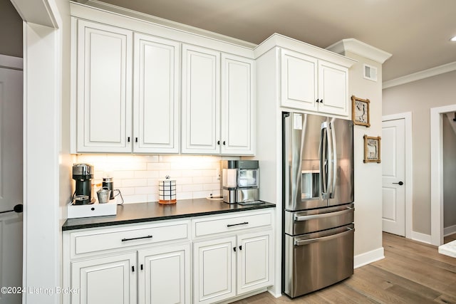 kitchen with white cabinetry, decorative backsplash, and stainless steel fridge with ice dispenser