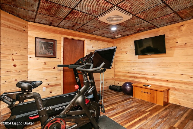 workout area with hardwood / wood-style floors and wood walls