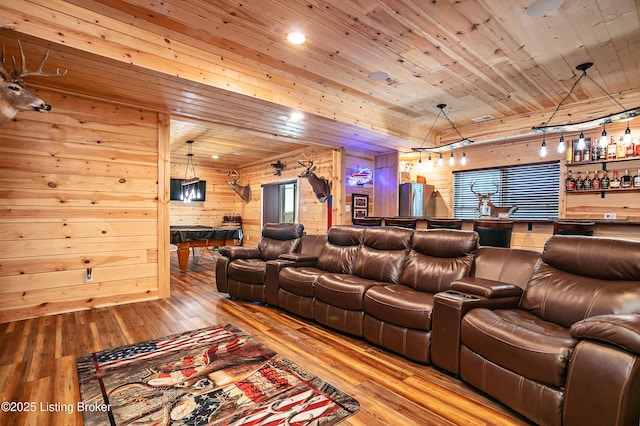 home theater room with bar area, wood walls, wood ceiling, and light hardwood / wood-style flooring