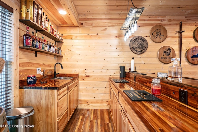 kitchen with dark hardwood / wood-style floors, wooden walls, butcher block countertops, sink, and wooden ceiling