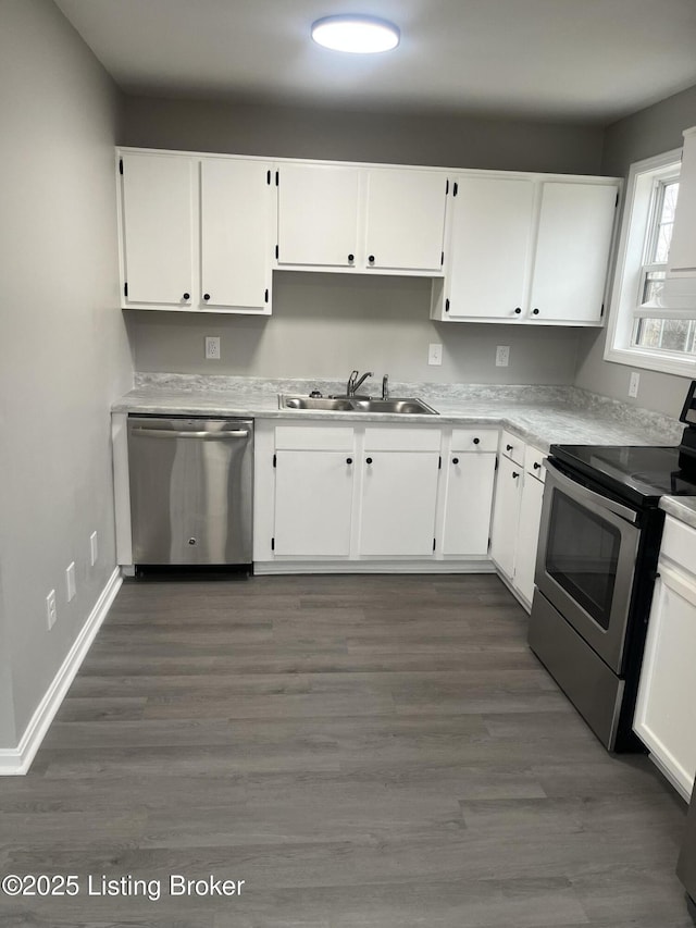 kitchen with white cabinetry, sink, dark hardwood / wood-style floors, and appliances with stainless steel finishes