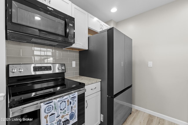 kitchen with tasteful backsplash, light hardwood / wood-style flooring, stainless steel appliances, and white cabinets