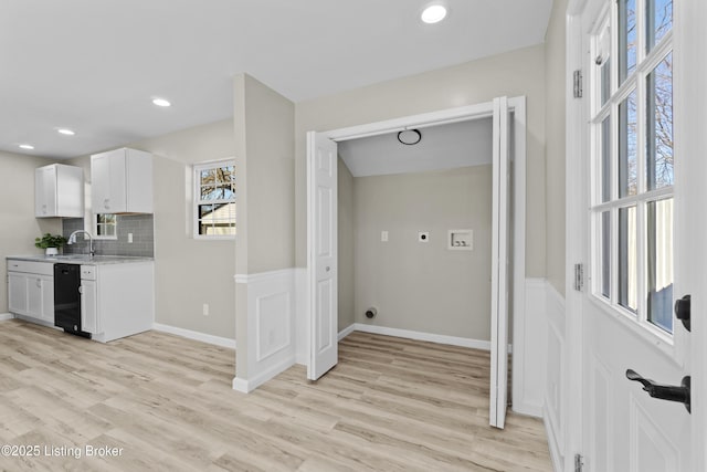 washroom featuring hookup for a washing machine, sink, and light wood-type flooring