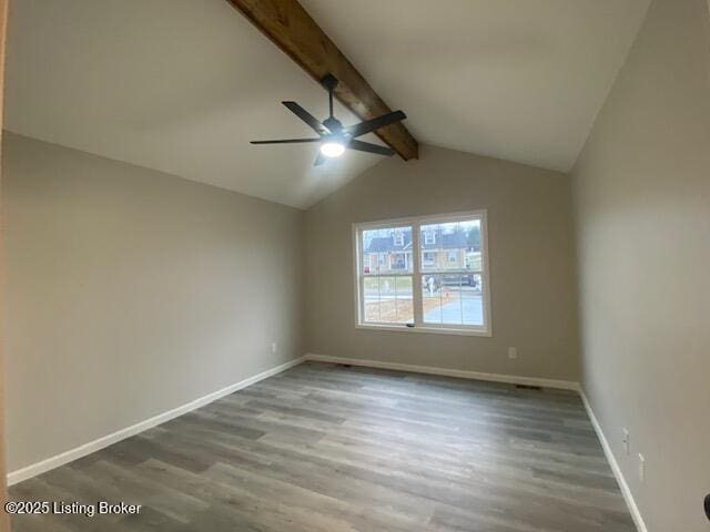 empty room with lofted ceiling with beams, ceiling fan, wood finished floors, and baseboards