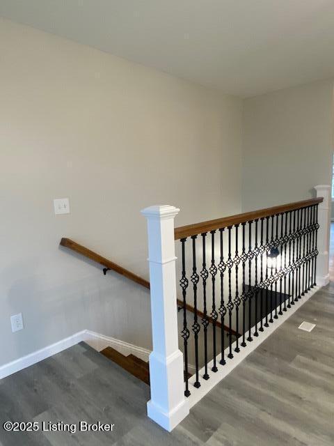 staircase with baseboards and wood finished floors