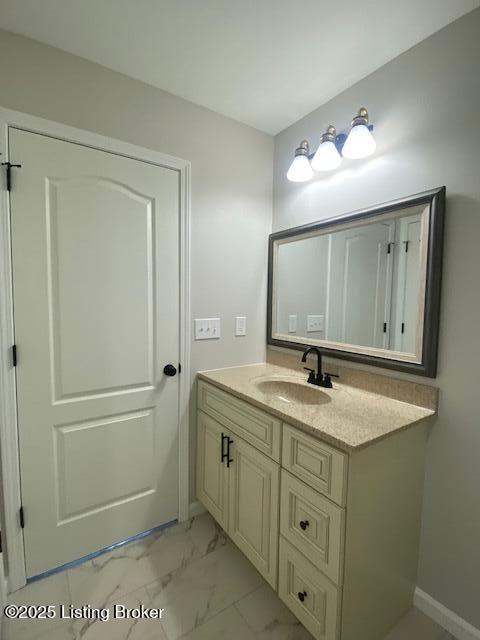 bathroom with marble finish floor and vanity