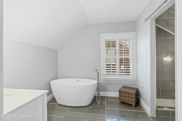 bathroom with lofted ceiling, vanity, and independent shower and bath