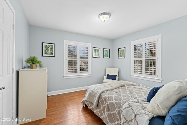 bedroom with multiple windows and hardwood / wood-style floors