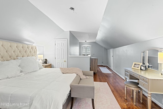 bedroom featuring dark wood-type flooring, lofted ceiling, and a closet