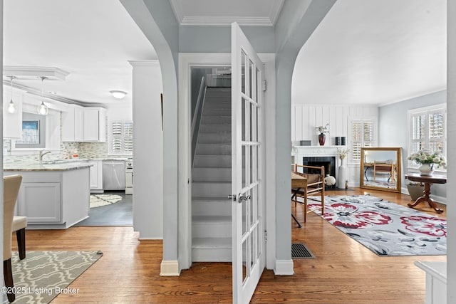 staircase with crown molding and hardwood / wood-style floors