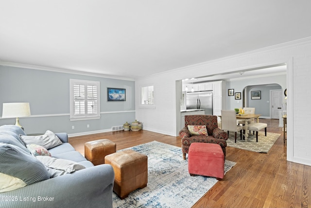 living room featuring ornamental molding and light wood-type flooring