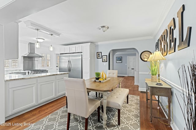 dining area with ornamental molding and wood-type flooring