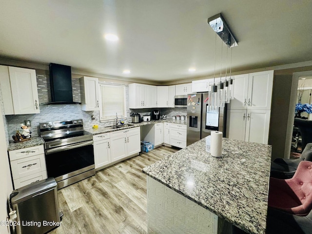 kitchen with a kitchen island, sink, white cabinets, stainless steel appliances, and wall chimney exhaust hood