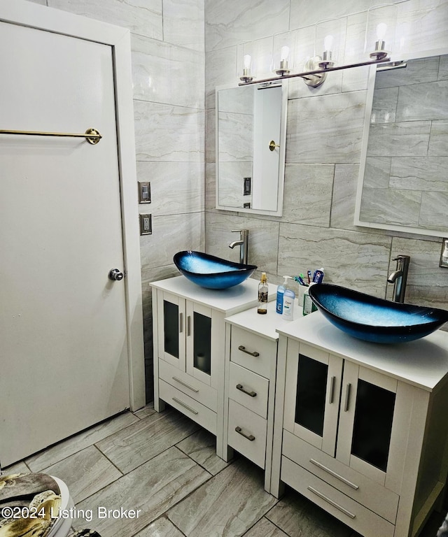 bathroom with vanity, tile walls, and decorative backsplash