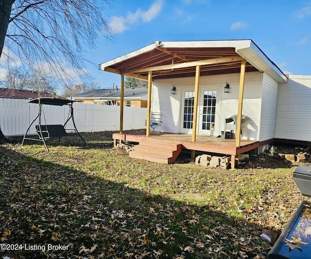 back of property with a wooden deck and french doors