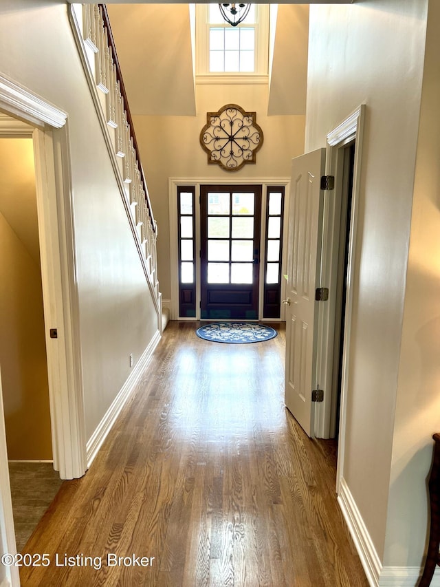 entrance foyer featuring a towering ceiling and dark hardwood / wood-style flooring