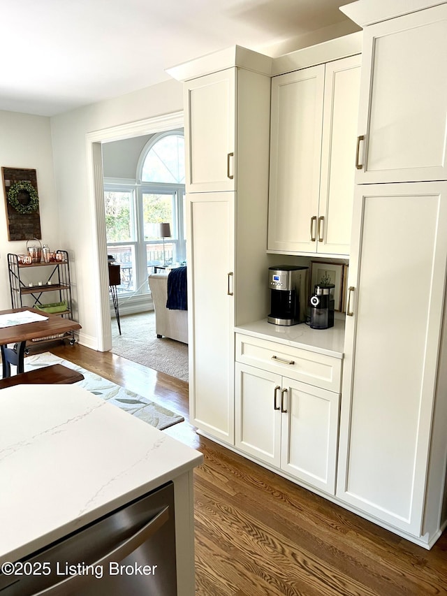 kitchen with dark hardwood / wood-style flooring, white cabinets, and light stone counters