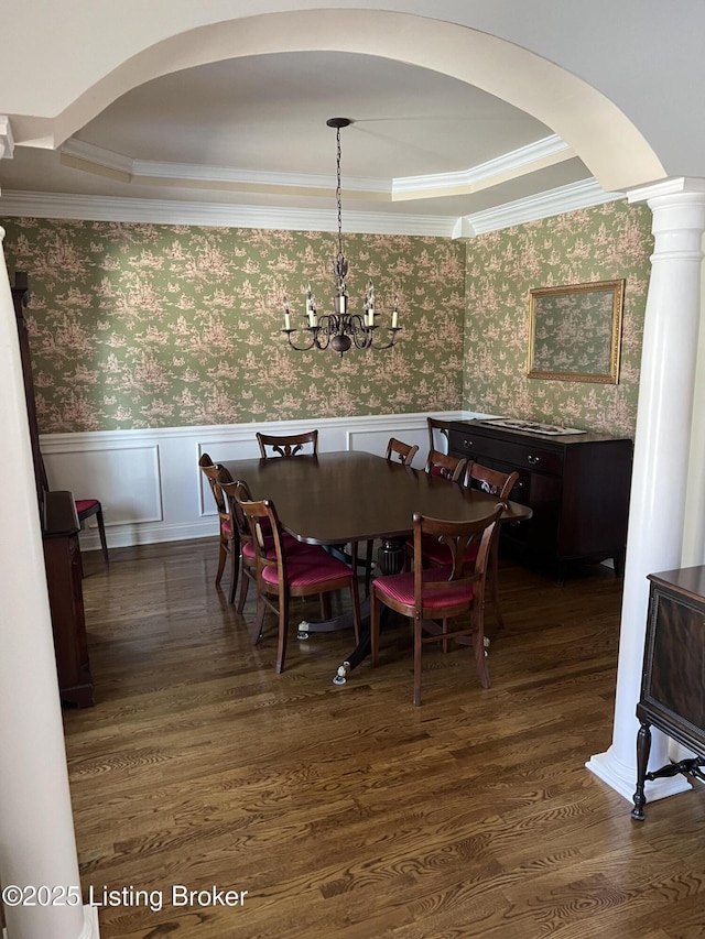 dining room featuring a raised ceiling, crown molding, dark hardwood / wood-style floors, and a notable chandelier