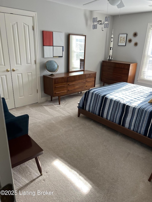 bedroom featuring light carpet, multiple windows, a closet, and ceiling fan