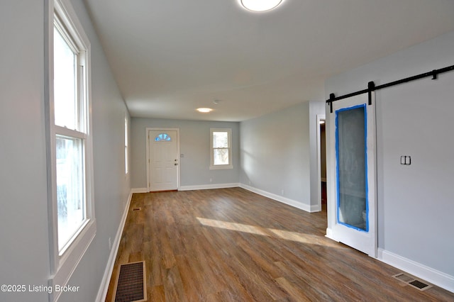 foyer entrance featuring wood-type flooring and a barn door